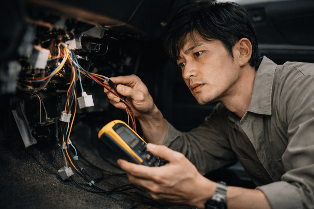 配線作業に苦戦する日本人男性のDIY作業シーン