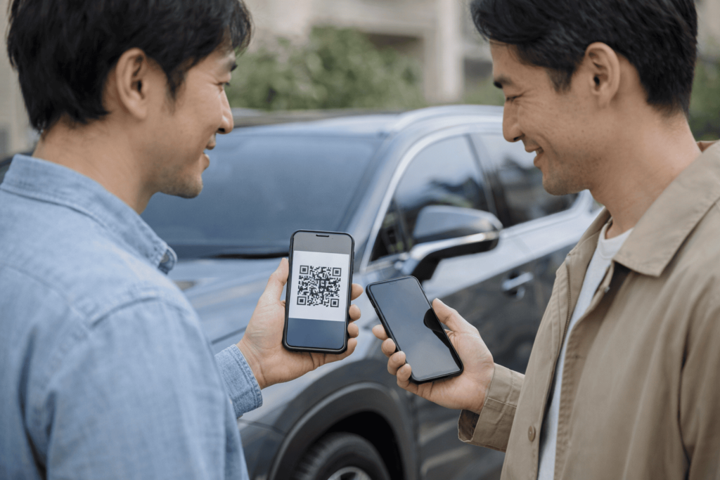 駐車場でスマホのQRコードを使ってデジタルキーをシェアする男性2人の様子