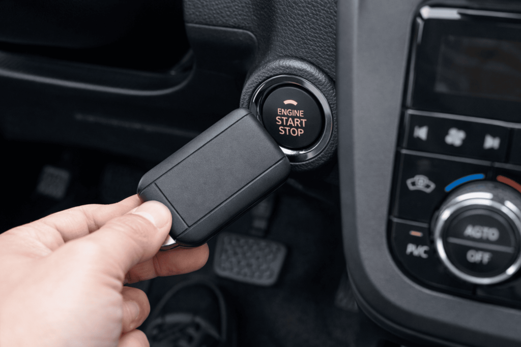 スマートキーを車のスタートボタンに近づけて緊急始動する方法をイメージした車内ビジュアル。